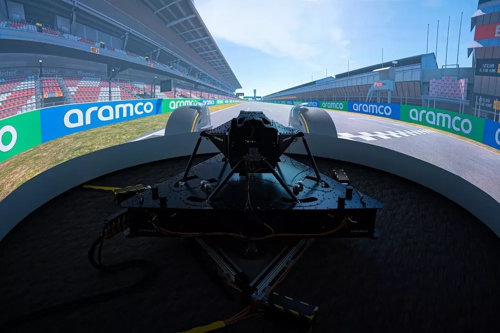 Rear view of the Dynisma DMG-1 motion platform integrated with an immersive wraparound screen showing a Formula 1 track, used for the Ferrari F1 simulator